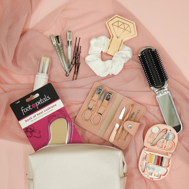 Collection of beauty and grooming tools on a pink fabric background