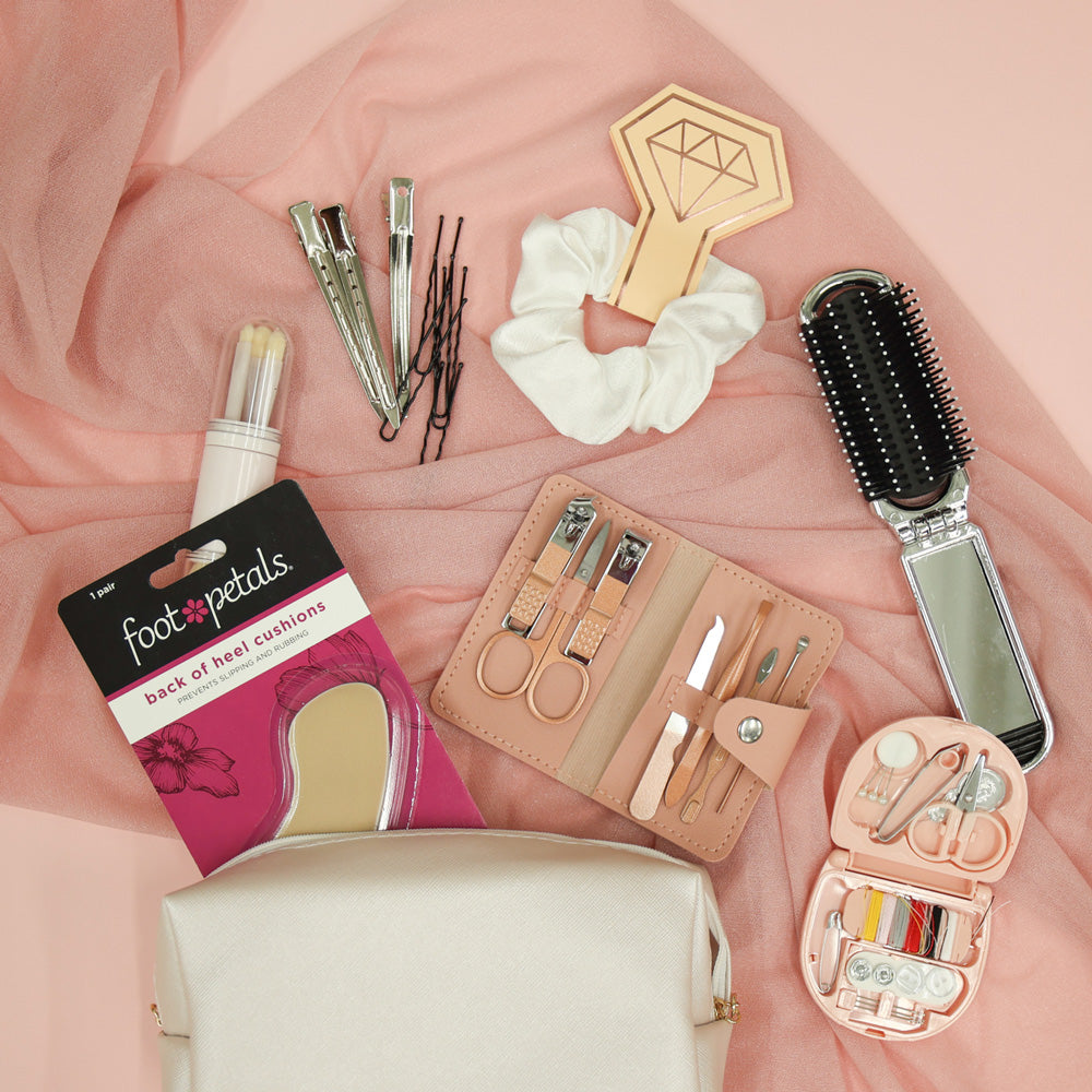 Collection of beauty and grooming tools on a pink fabric background