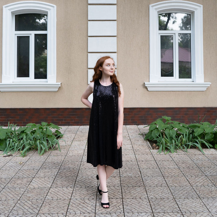 Woman standing in front of tan building while wearing black heels with Foot Petals 3/4 Insert Cushions inside #color_khaki