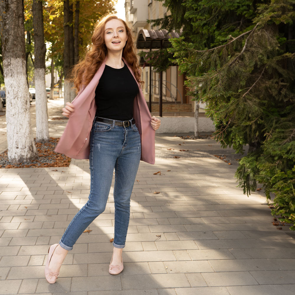 Girl standing on sidewalk while wearing pink flats with Foot Petals Arch Support Cushions inside #color_black