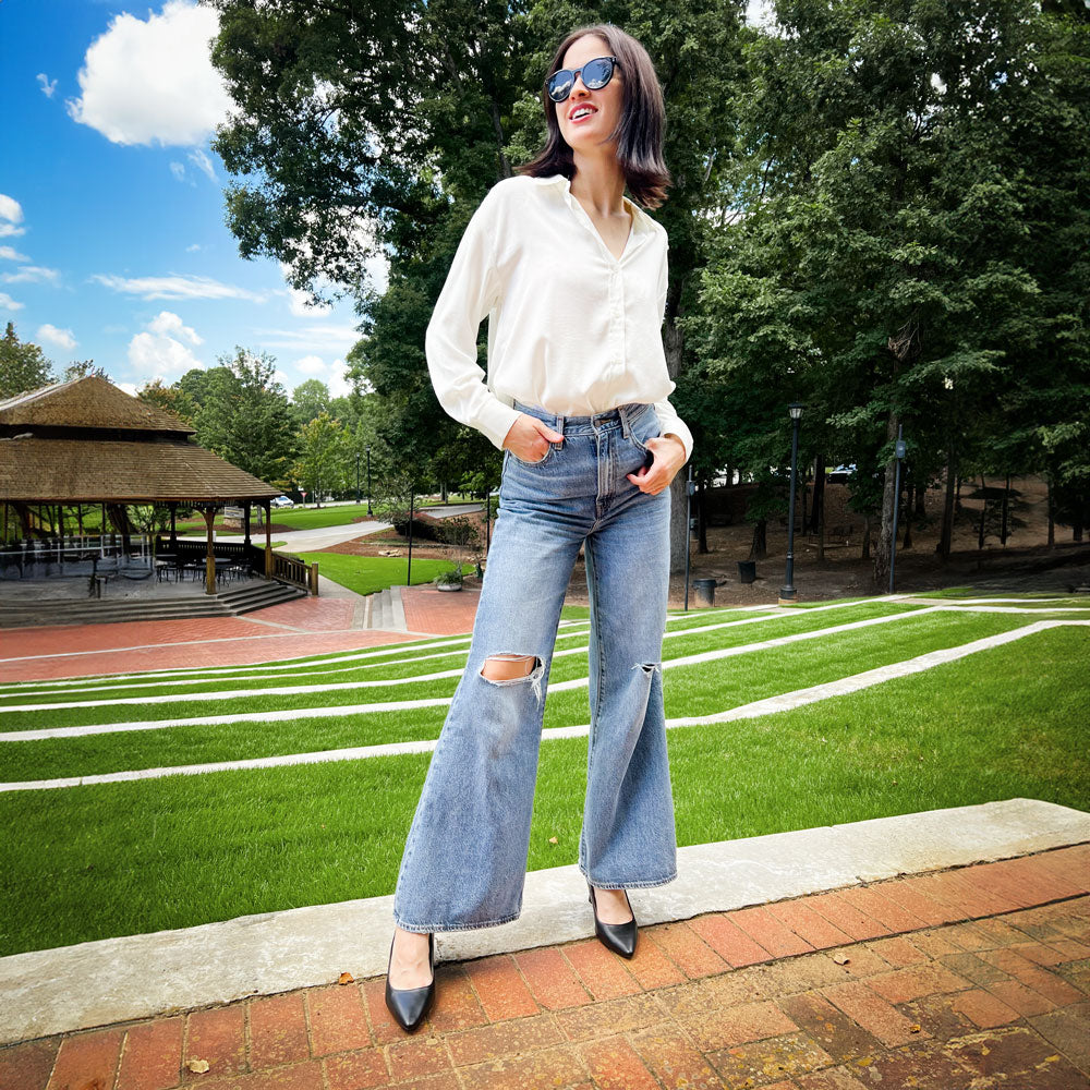 Woman standing on brick patio at a park while wearing black high heels with Foot Petals Back of Heel Cushions inside #options_clear