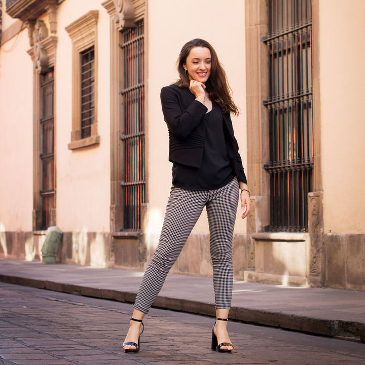 Woman standing on stone sidewalk while wearing black high heels with Foot Petals Ball of Foot Cushions inside #color_assorted-3-pairs