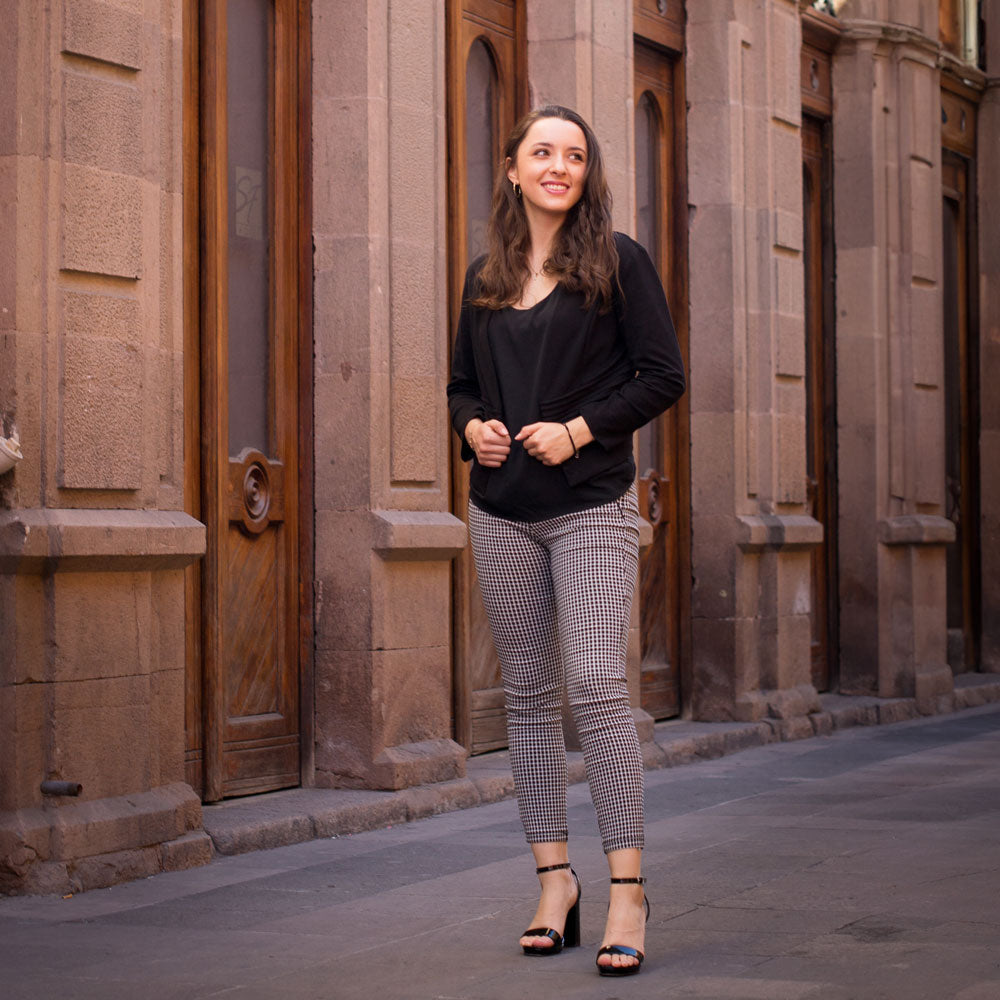 Woman standing on stone sidewalk in front of old building while wearing  black high heels with Foot Petals Ball of Foot Cushions inside #color_black