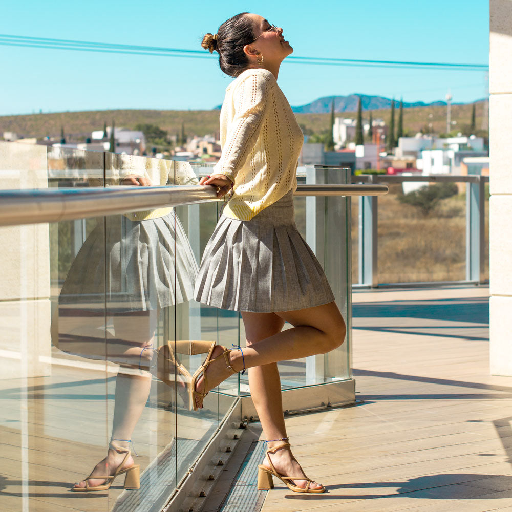 Woman standing against glass railing on balcony while wearing high heeled sandals with Foot Petals Ball of Foot Cushions inside #options_clear-pink-2-pairs