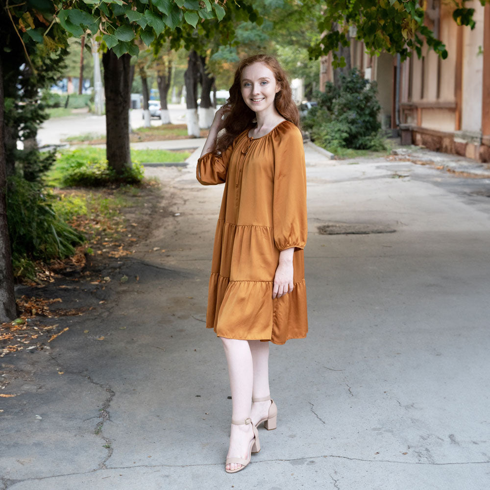 Woman standing on concrete sidewalk while wearing tan high heels with Ball of Foot, Strap, Heel Cushions from the Foot Petals Shoe Emergency kit