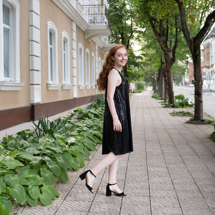 Woman standing in front of building on sidewalk while wearing black high heels with Foot Petals Spot Dot Cushions inside