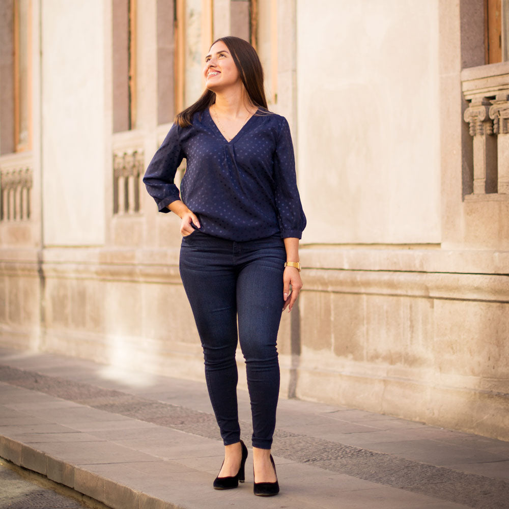 Woman standing in front of old concrete building, standing on sidewalk while wearing black high heels with Foot Petals Under Heel Cushions inside